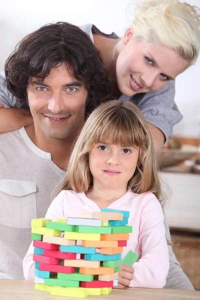 Casal jogando um jogo de empilhamento com sua filha — Fotografia de Stock