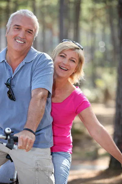 Man en vrouw met een fiets in het forest — Stockfoto