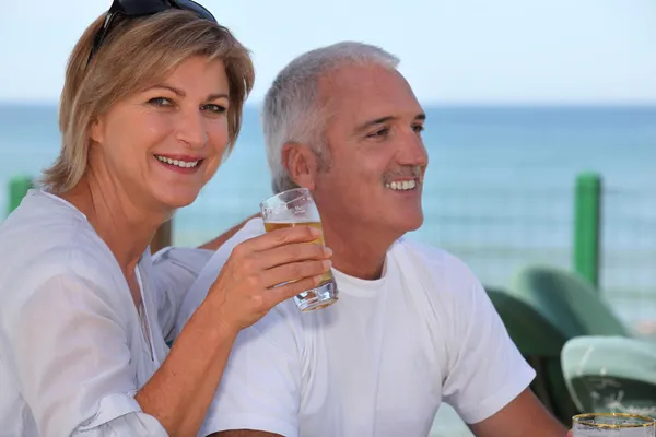 Äldre par med färskt öl Café nära havet — Stockfoto