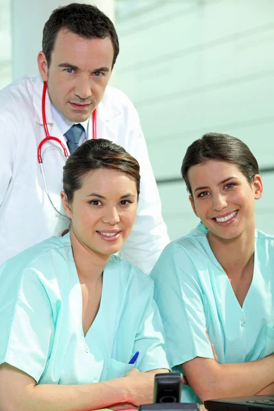 Médico de pie con dos enfermeras en un centro de enfermería —  Fotos de Stock