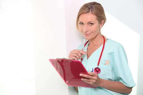 Enfermeira olhando para anotações — Fotografia de Stock