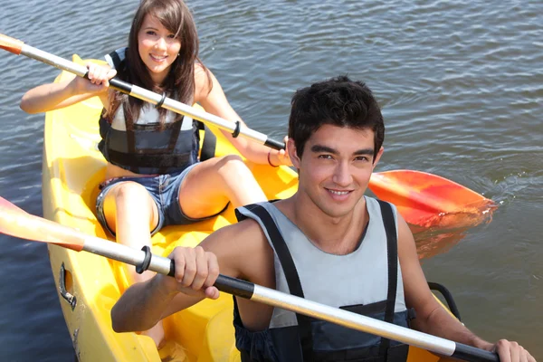 Couple paddling in a canoe — Stockfoto