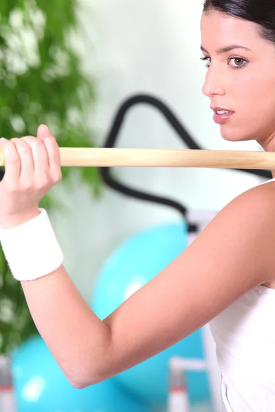 Kobieta za pomocą drewniany słup na siłowni — Zdjęcie stockowe