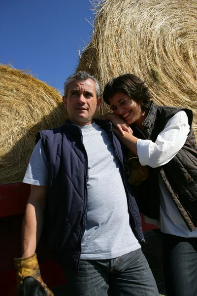 Rolnik i jego żona przed bele siana — Zdjęcie stockowe