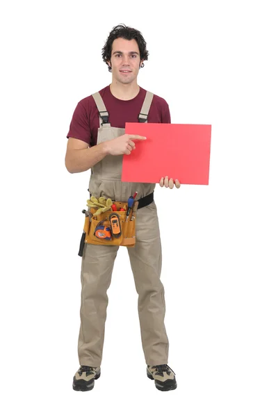 Handyman pointing at red panel — Stock Photo, Image