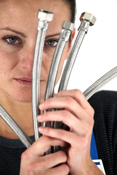 Woman with metal flexible hoses — Stock Photo, Image