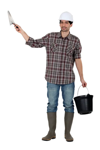 Construtor com uma espátula e um balde — Fotografia de Stock