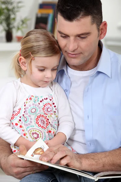 A father reading to her daughter. Stock Picture