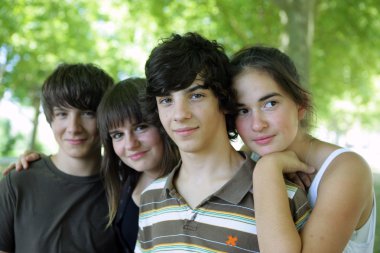 Four children stood together in park clipart