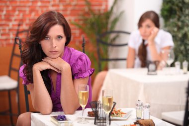 Angry woman at the restaurant, on the table, an unopened gift and flutes o clipart