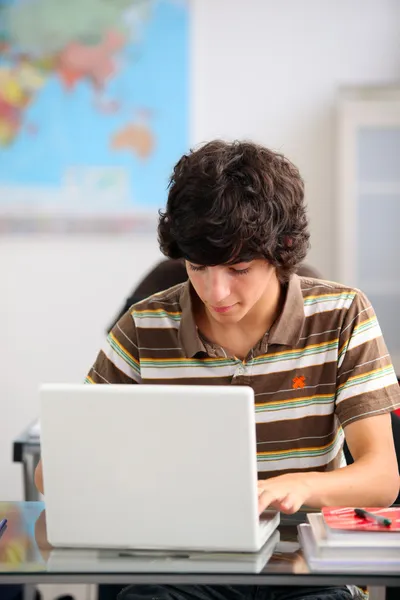 Подросток, использующий ноутбук в школе — стоковое фото