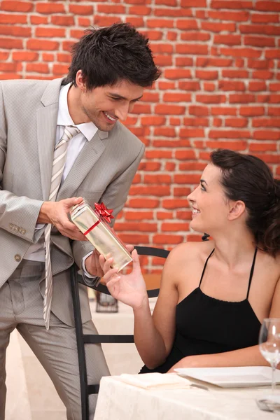 Mann macht seinen Freundinnen in Restaurant ein Geschenk — Stockfoto