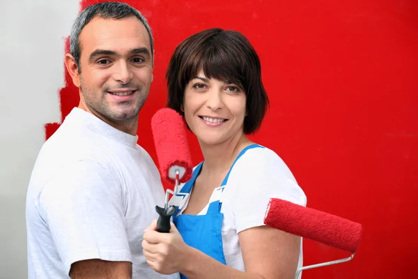 Couple painting wall with roller Stock Photo