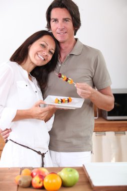 A couple eating fruit skewers clipart