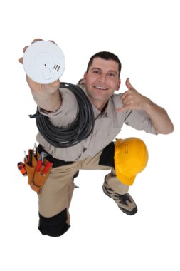 Electrician with a smoke alarm clipart