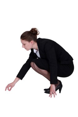 Businesswoman picking a speck up off the floor clipart