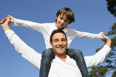 Little boy on his father's shoulders clipart