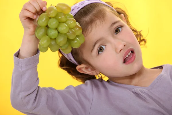 Маленькая девочка ест виноград — стоковое фото