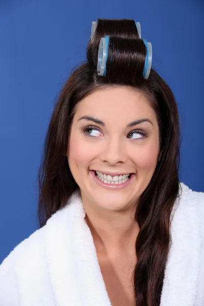 Красивая женщина кладет ролики в волосы — стоковое фото