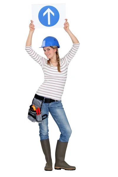 Female builder in studio holding road sign — Stock Photo, Image