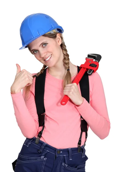 En kvinnlig byggnadsarbetare med en skiftnyckel. — Stockfoto