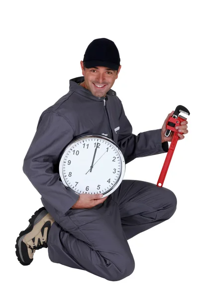 Plumber holding clock and wrench — Stock Photo, Image