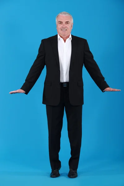 Businessman standing on tiptoes — Stock Photo, Image