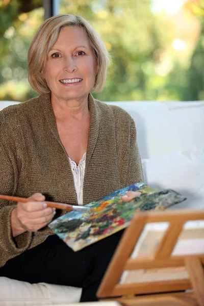50 yıl yaşlı kadın boyama — Stok fotoğraf