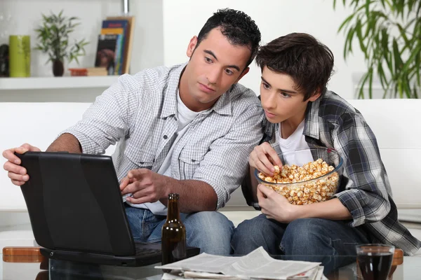 En far och son tittar på ett spel. — Stockfoto