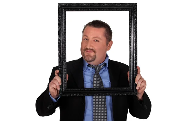 Businessman carrying frame in front of his face — Stock Photo, Image