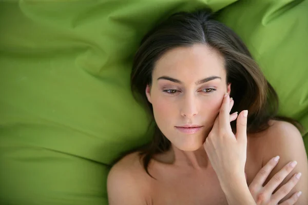Jonge vrouw rusten op een bed — Stockfoto