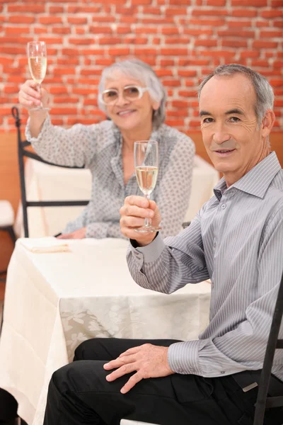 Bejaarde echtpaar drinken champagne — Stockfoto