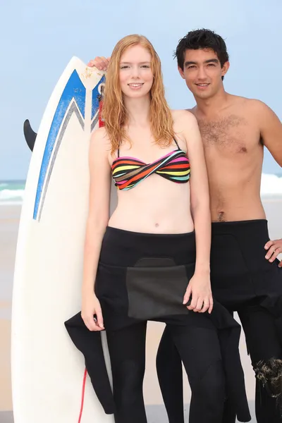 Junge und Mädchen mit Surfbrett — Stockfoto