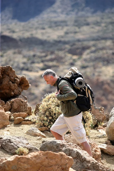 Hombre mochilero a través de las montañas —  Fotos de Stock