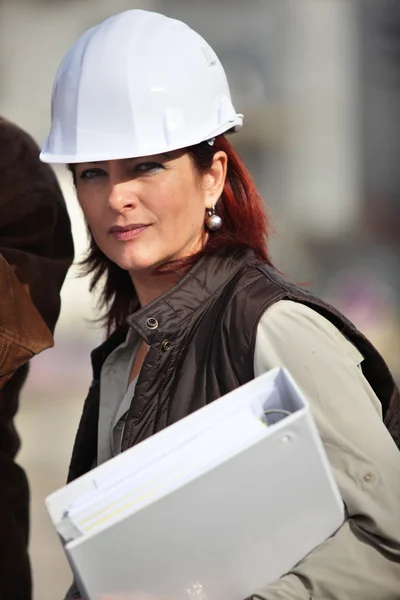 Een ingenieur holding een binder en dragen van een hoed veiligheid — Stockfoto
