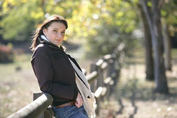 Vrouw leunend tegen hek op landbouwgrond — Stockfoto