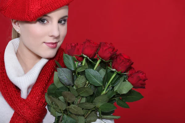 Eine süße Blondine hält einen Strauß Rosen in der Hand. — Stockfoto