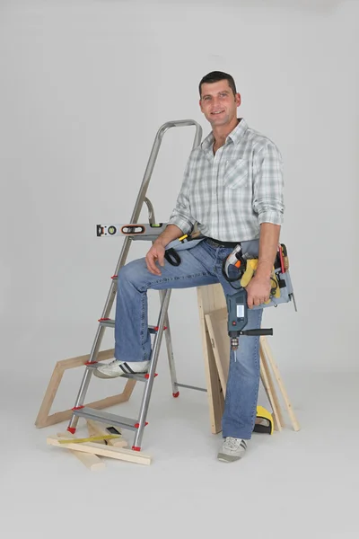 Homme de métier posant avec ses matériaux de construction — Photo