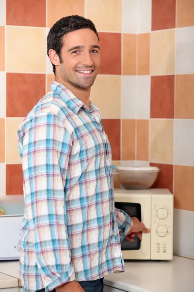 Homem aquecimento de alimentos em microondas — Fotografia de Stock