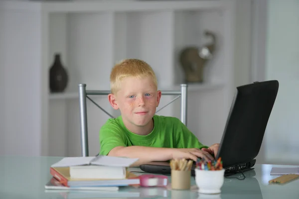 Мальчик за столом с ноутбуком — стоковое фото