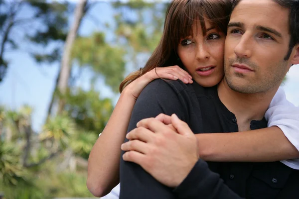 Serious couple embracing in a park — Stock Photo, Image