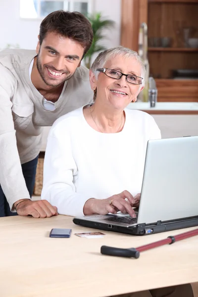 Hijo ayudando a mamá en el ordenador portátil — Foto de Stock