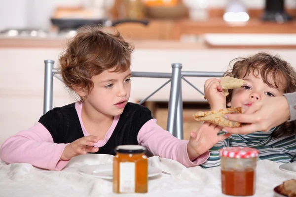 Two children eating breakfast — Stock Photo, Image