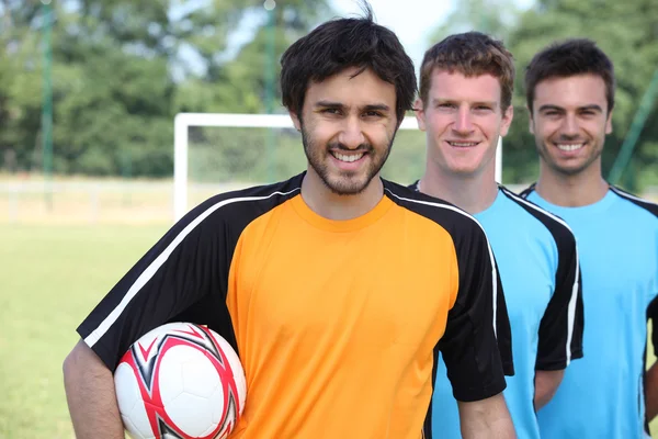 在进球的阵容中的三个足球运动员 — 图库照片