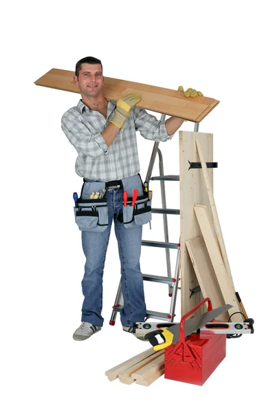 Ein Handwerker mit einer Holzplanke — Stockfoto