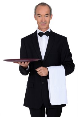 Senior waiter holding empty tray clipart