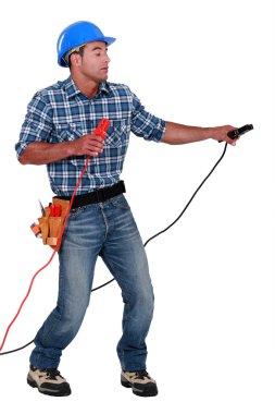 Manual worker with a set of jump leads clipart