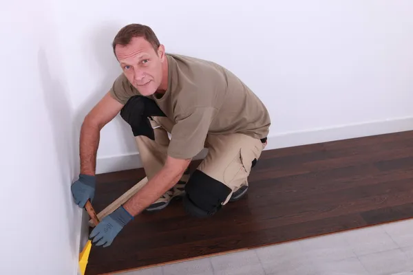 Człowiek układanie podłogi drewniane — Zdjęcie stockowe