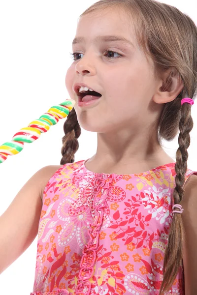 Маленькая девочка с разноцветным леденцом — стоковое фото