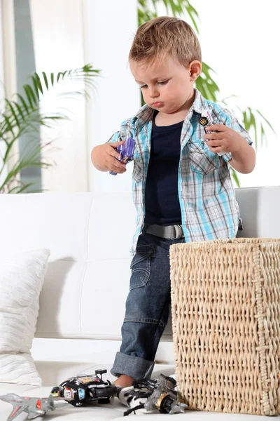 Маленький мальчик играет с игрушечными машинами — стоковое фото